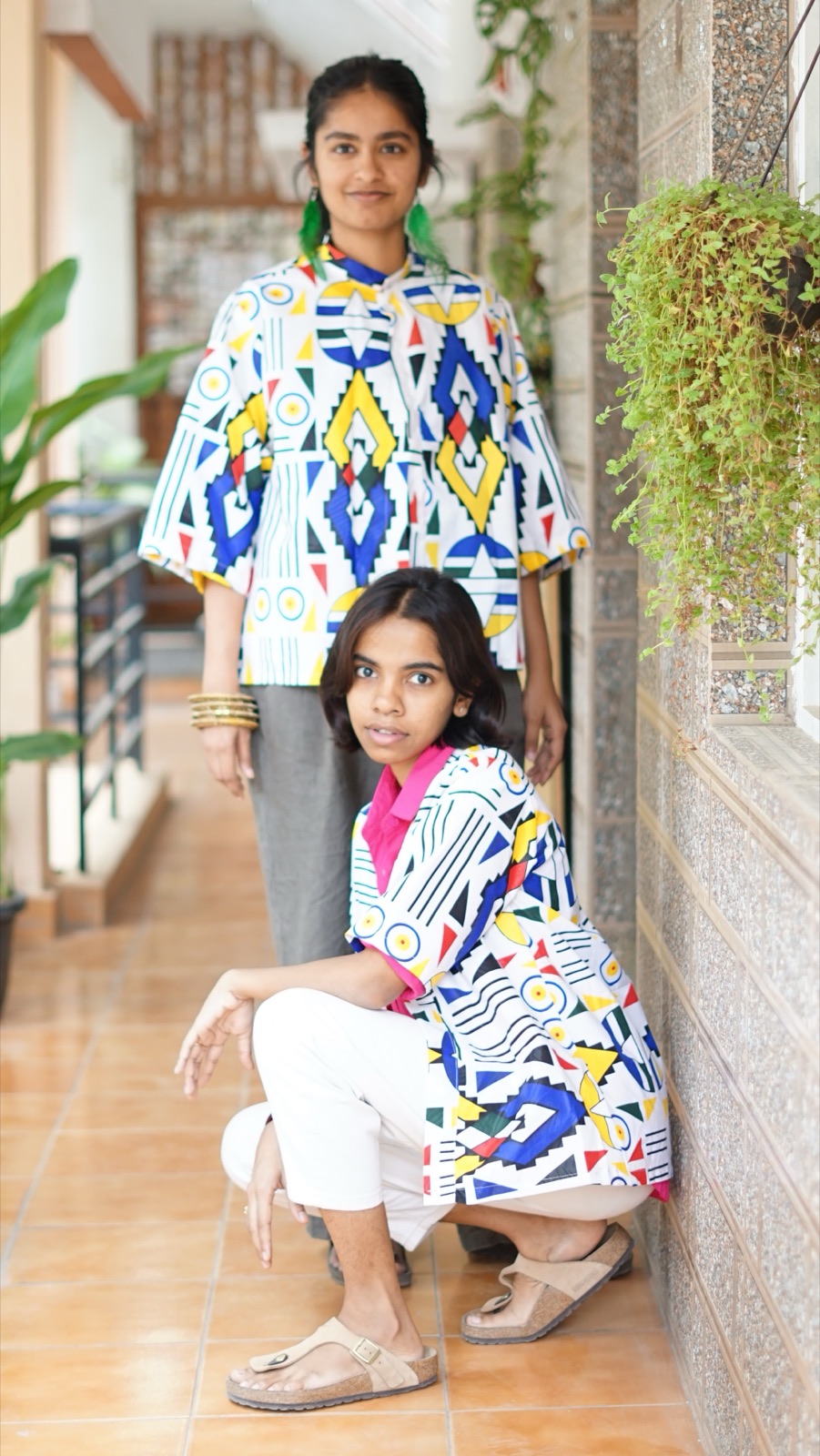 Two models in geometric pieces, one crouching in front